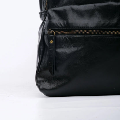 Black leather bag with gold zipper on a white background