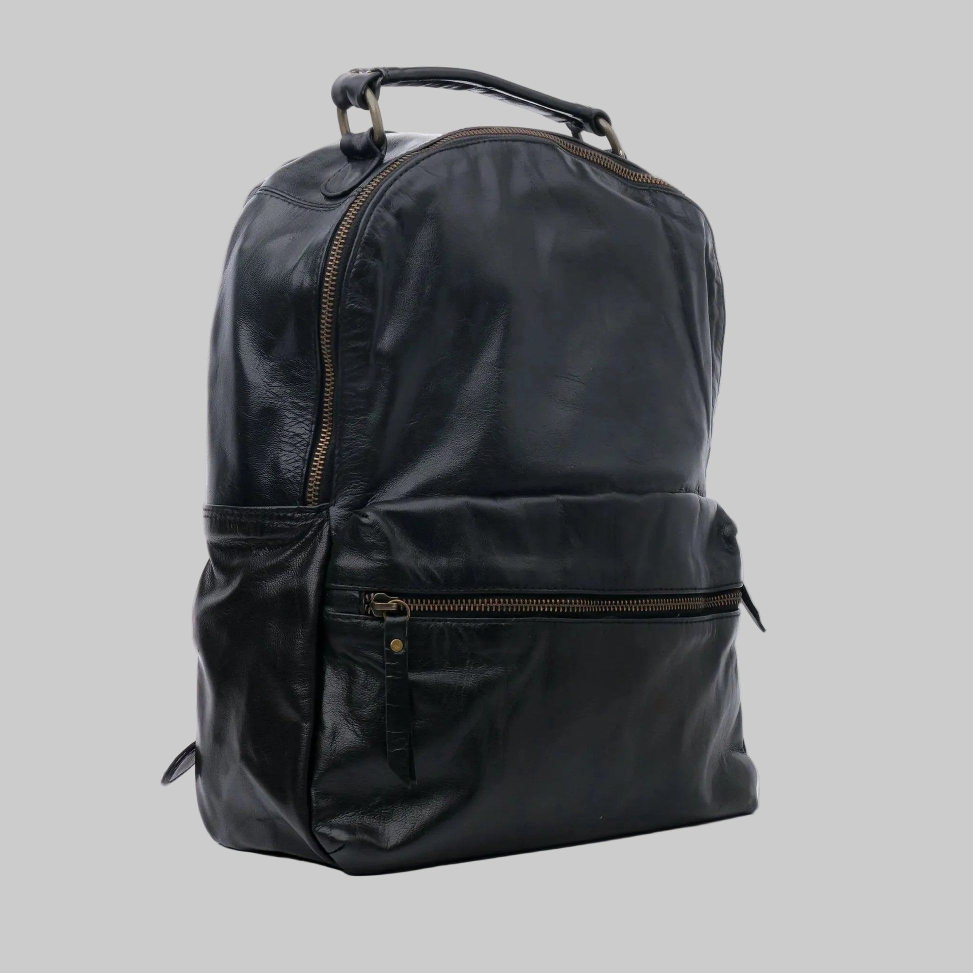 A black leather backpack with gold-tone zippers and a top handle, photographed on a clean white background.