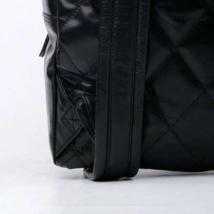 Close-up of a black quilted backpack on a white background