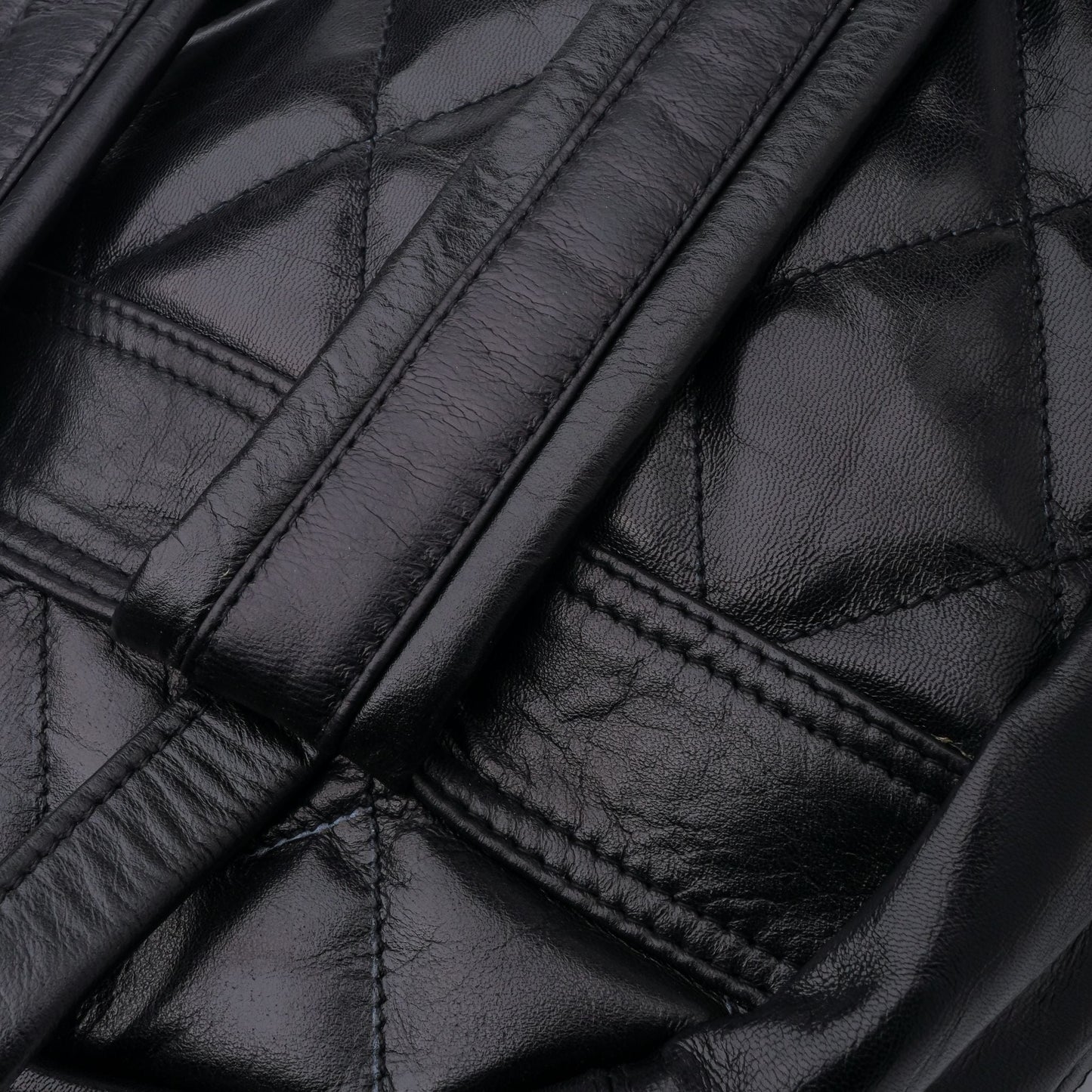Close-up of a black quilted leather jacket with stitching details.
