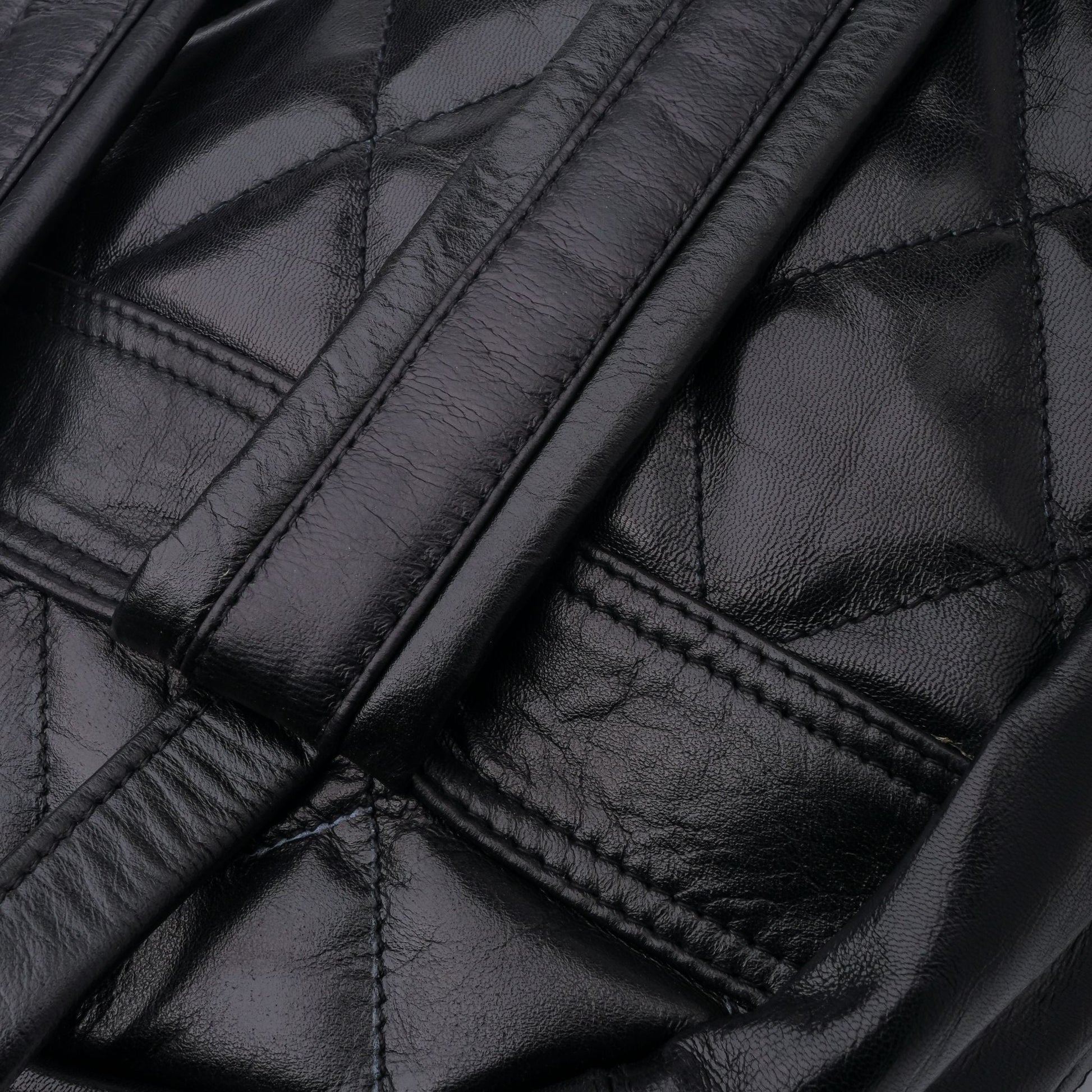 Close-up of a black quilted leather jacket with stitching details.