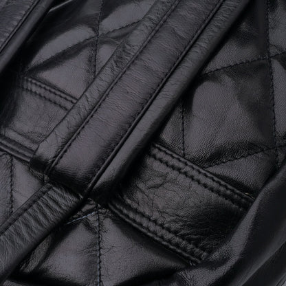 Close-up of a black quilted leather jacket with stitching details.