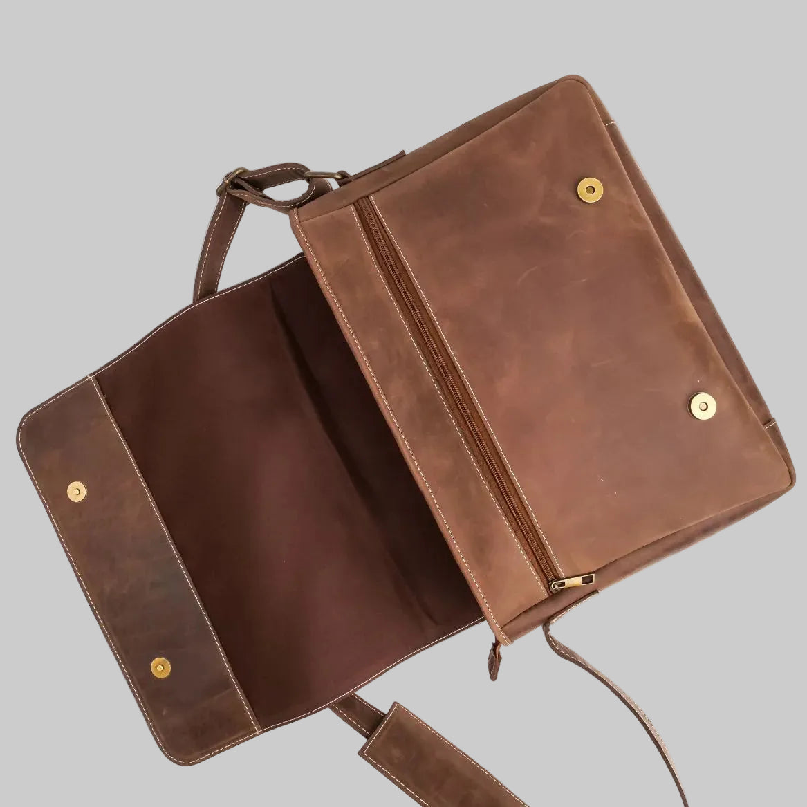 Brown leather clutch bag with gold studs on a white background