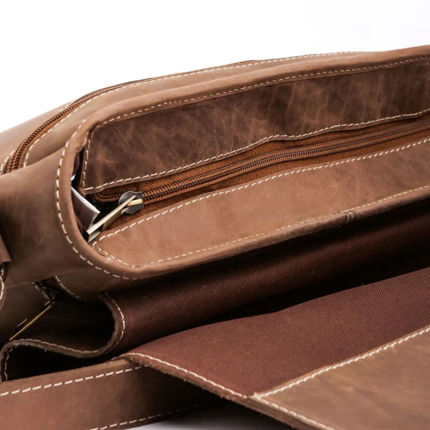 Close-up of a brown leather bag with zippers