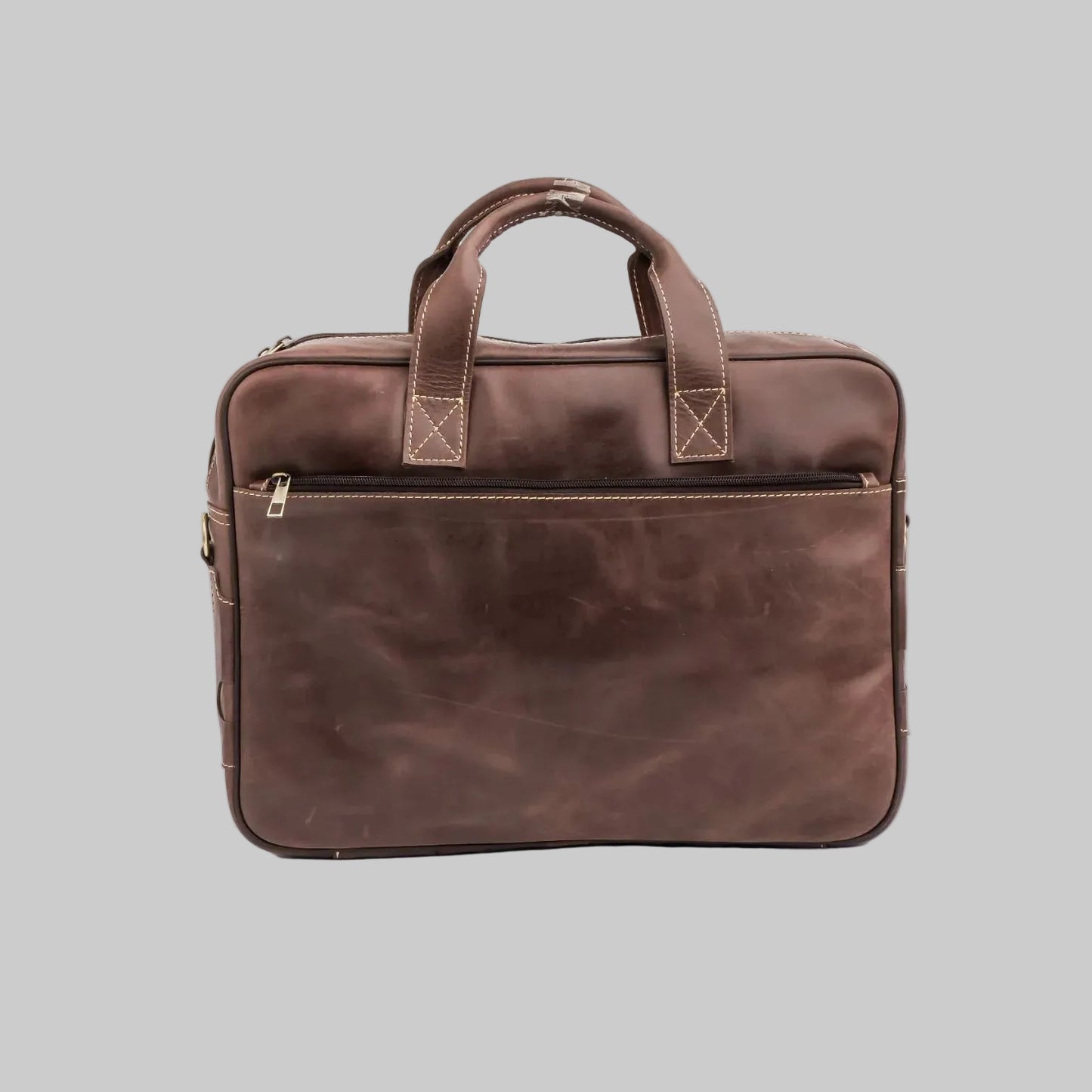 A dark brown distressed leather briefcase with dual top handles, a front zippered pocket, and brass hardware, photographed on a seamless white background.