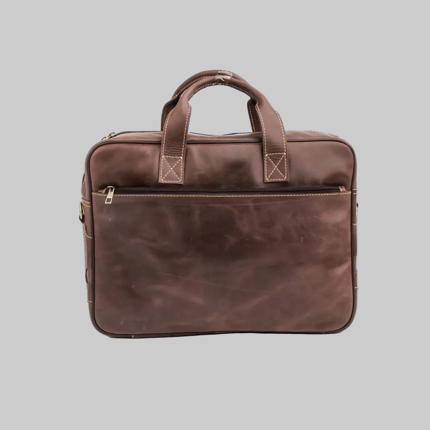 A dark brown distressed leather briefcase with dual top handles, a front zippered pocket, and brass hardware, photographed on a seamless white background.