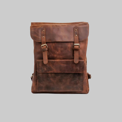 A brown distressed leather backpack with a front flap pocket and buckle straps, photographed against a plain white background.