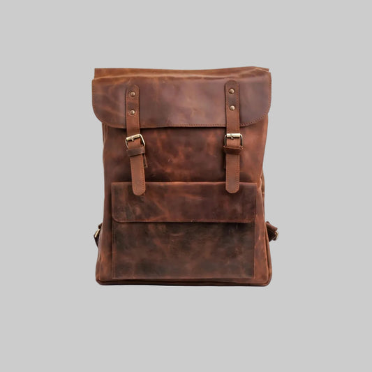 A brown distressed leather backpack with a front flap pocket and buckle straps, photographed against a plain white background.