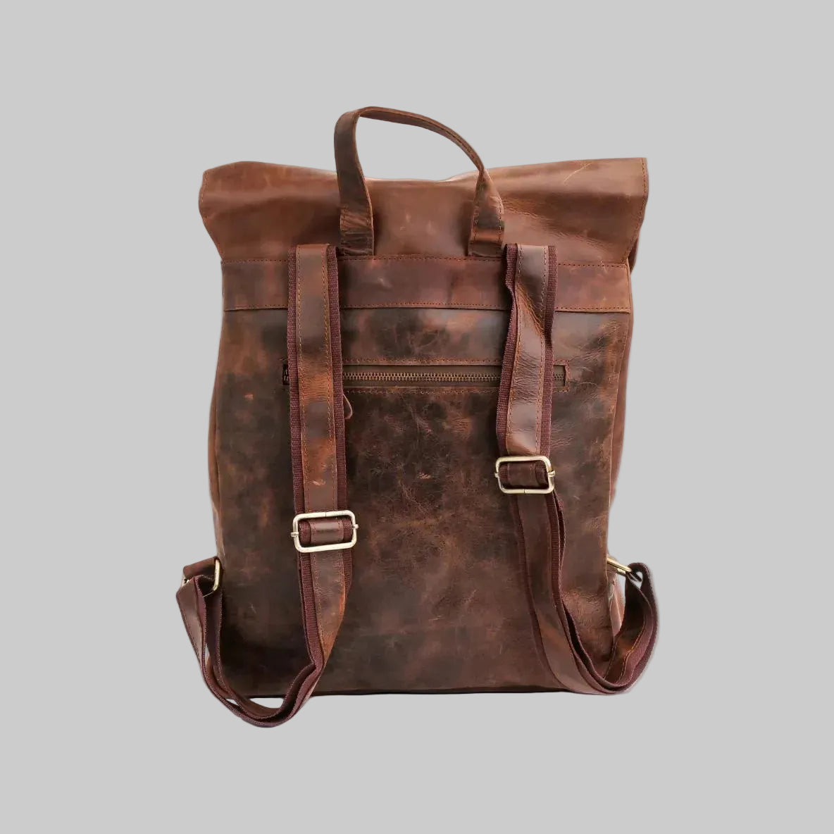 A dark brown distressed leather roll-top backpack with dual top handles, adjustable shoulder straps with metal buckles, and a front zippered pocket, shown on a plain white background.