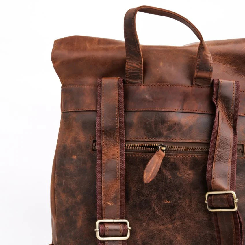 Brown leather backpack with gold buckles on a white background