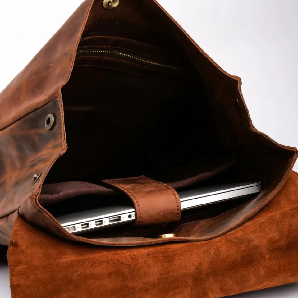 Brown leather bag with a laptop inside on a white background
