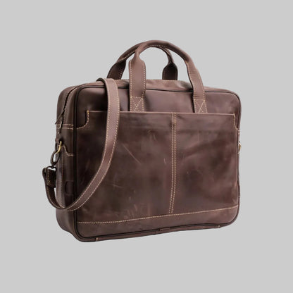 Brown leather briefcase with shoulder strap on a white background