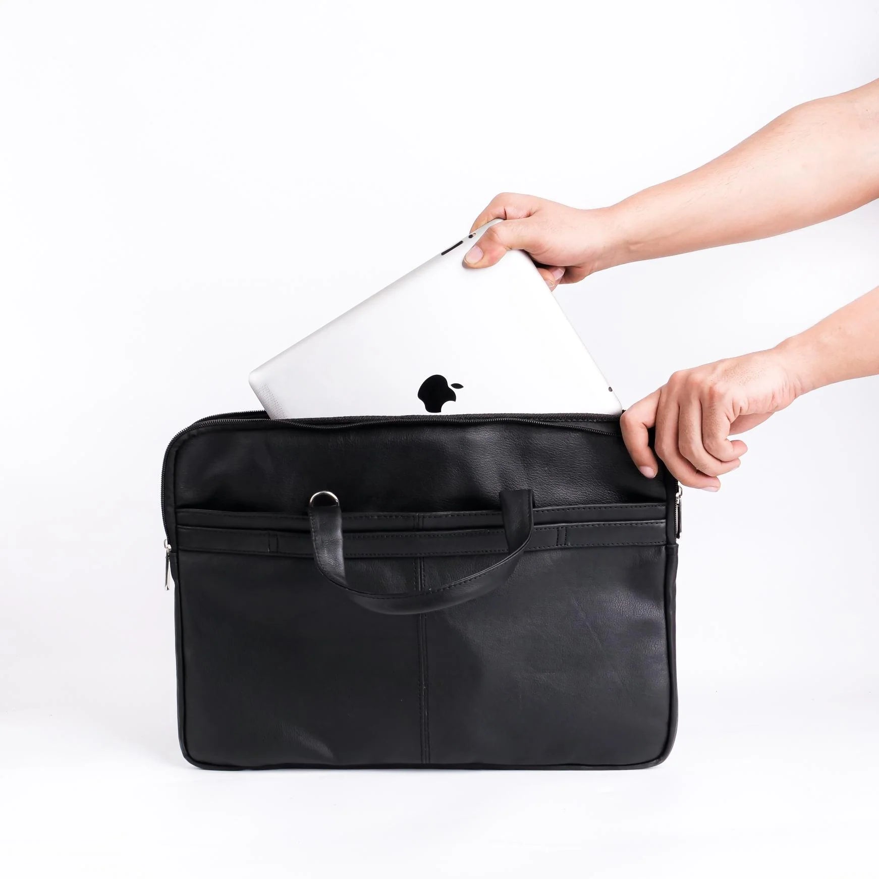 Person placing a laptop into a black briefcase on a white background