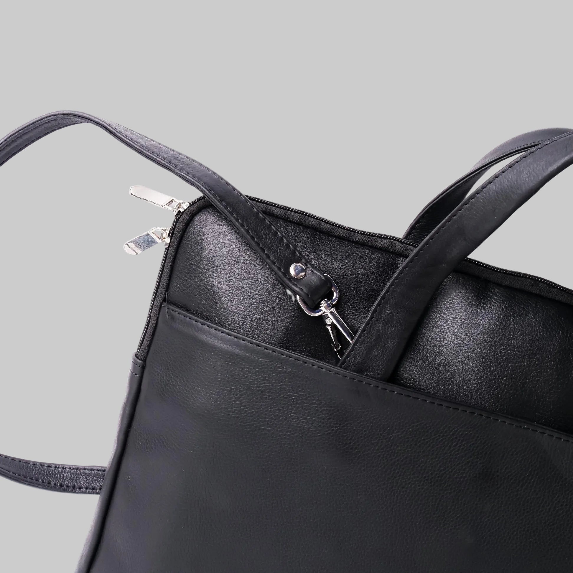 Black leather handbag with a clear plastic bag inside on a white background
