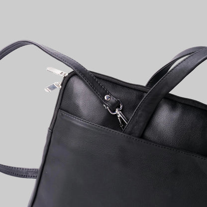 Black leather handbag with a clear plastic bag inside on a white background