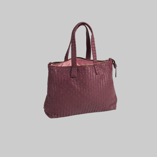 Woven handbag with a pink interior on a white background