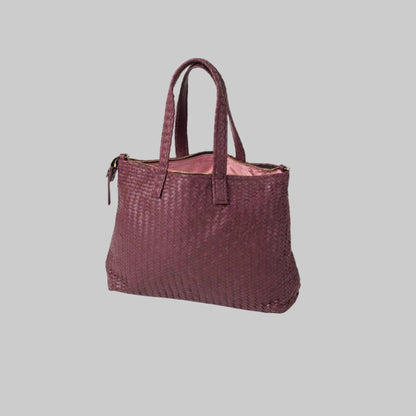 Woven handbag with a pink interior on a white background