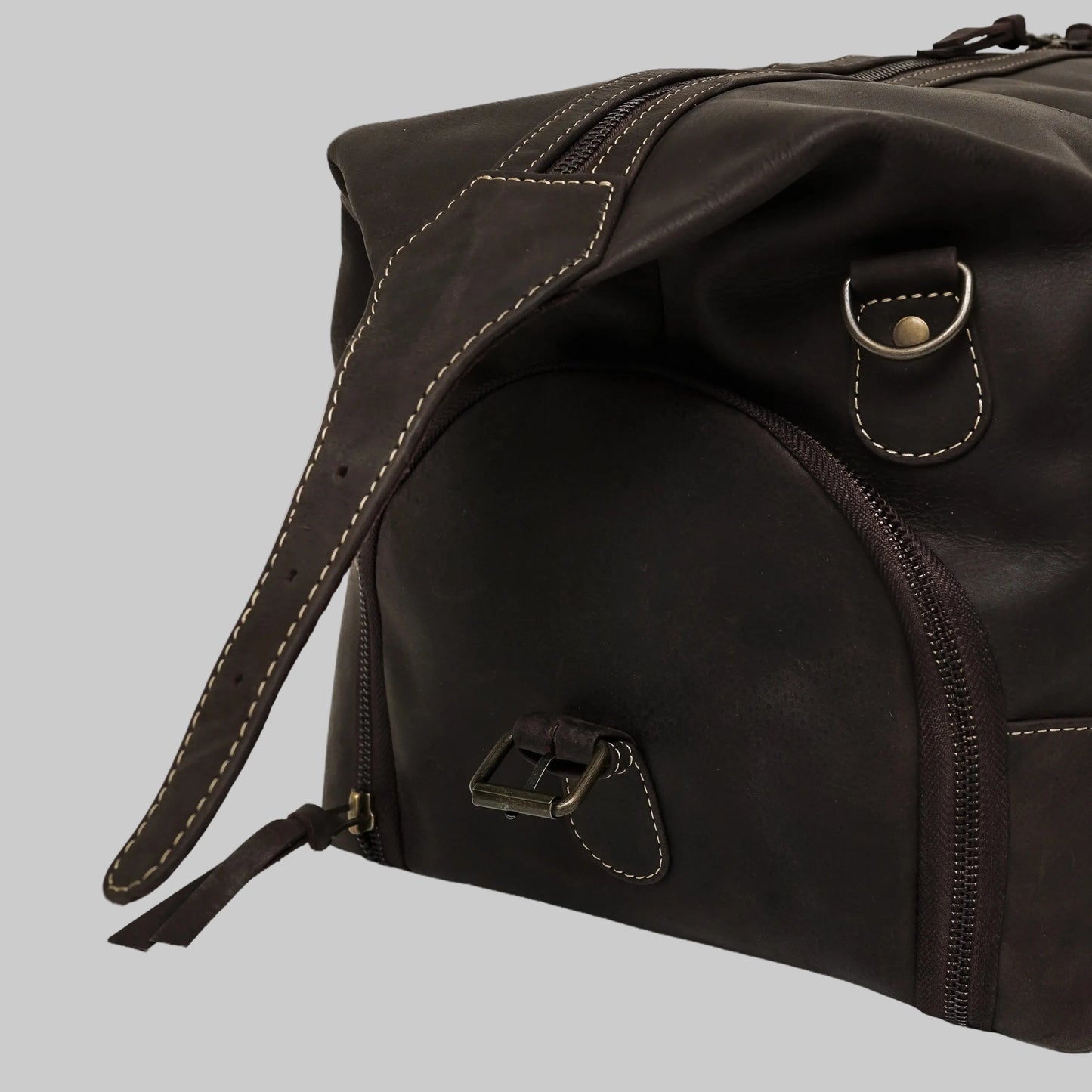 Brown leather duffel bag with strap on a white background