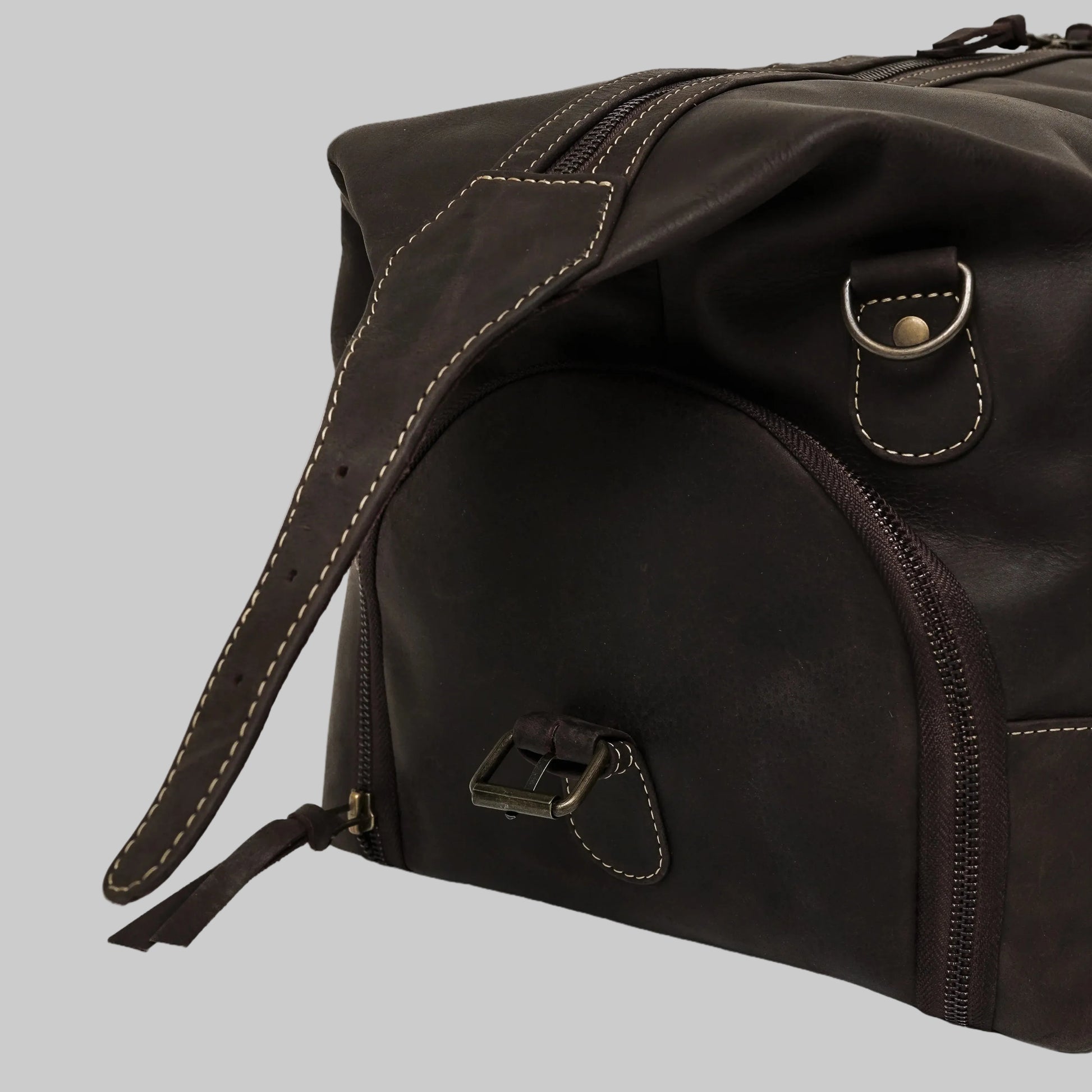 Brown leather duffel bag with strap on a white background