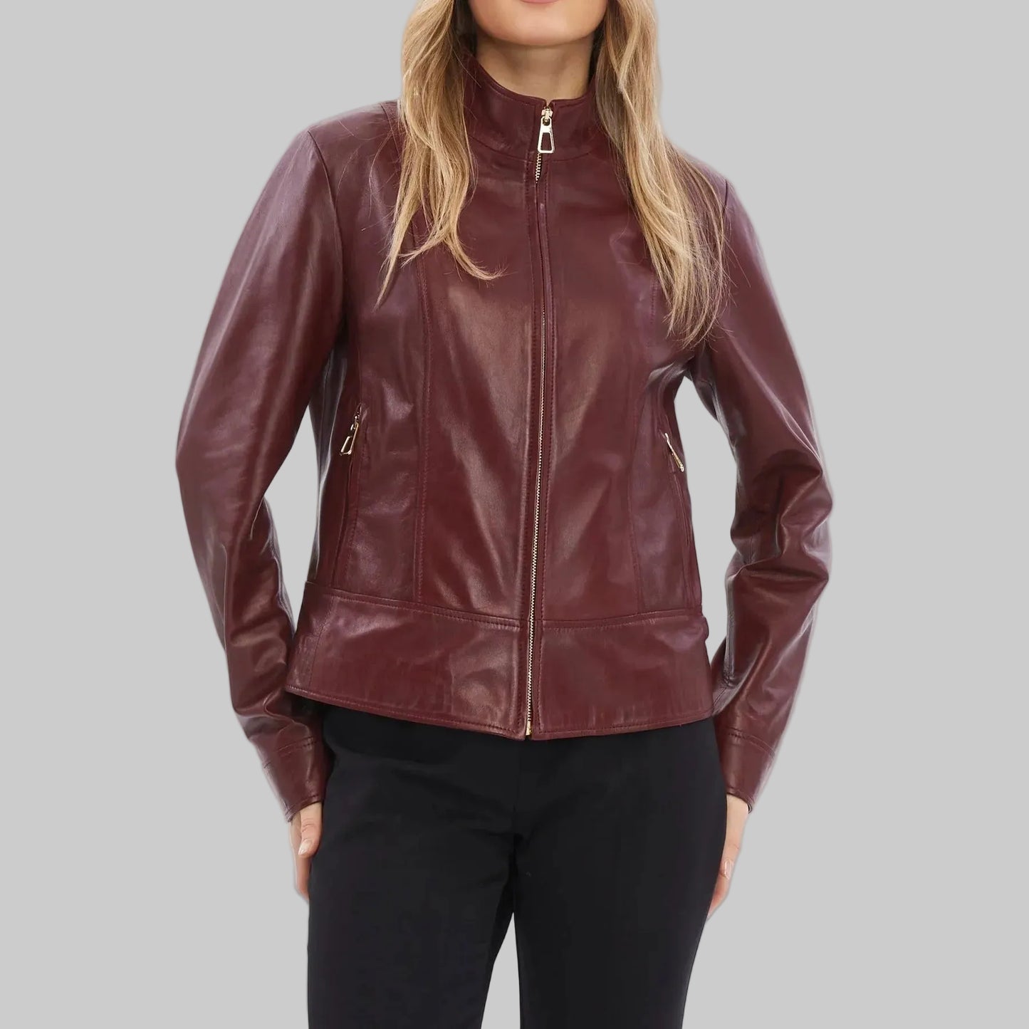 Woman wearing a burgundy leather jacket on a white background