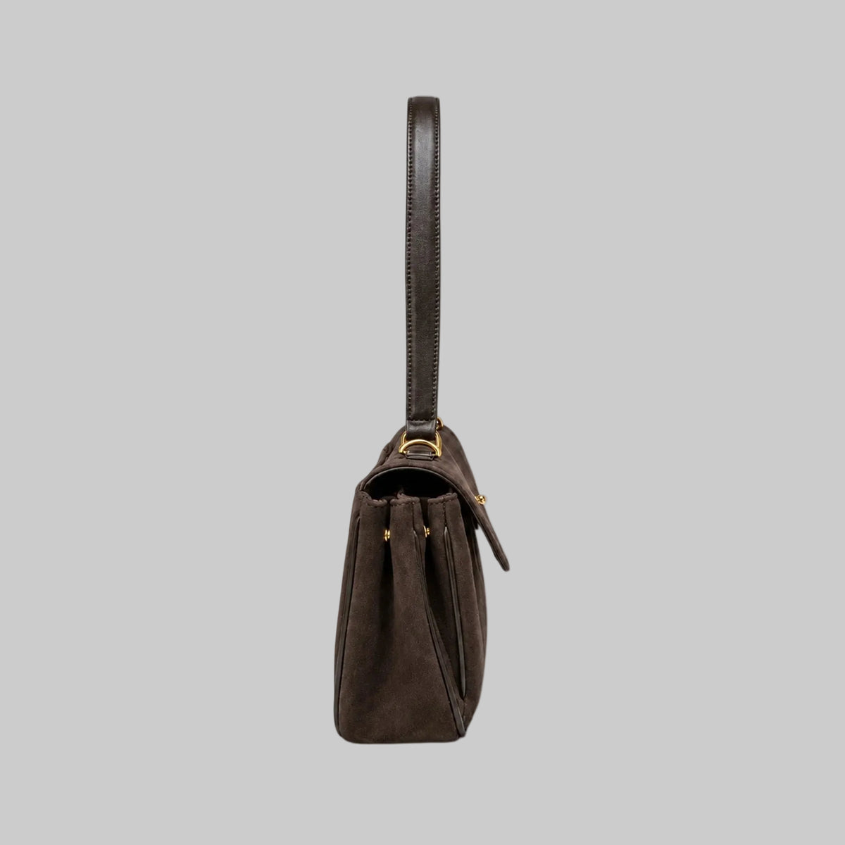 A dark brown suede shoulder bag with a single leather strap and gold-tone hardware, shown from a side profile view against a plain white background.