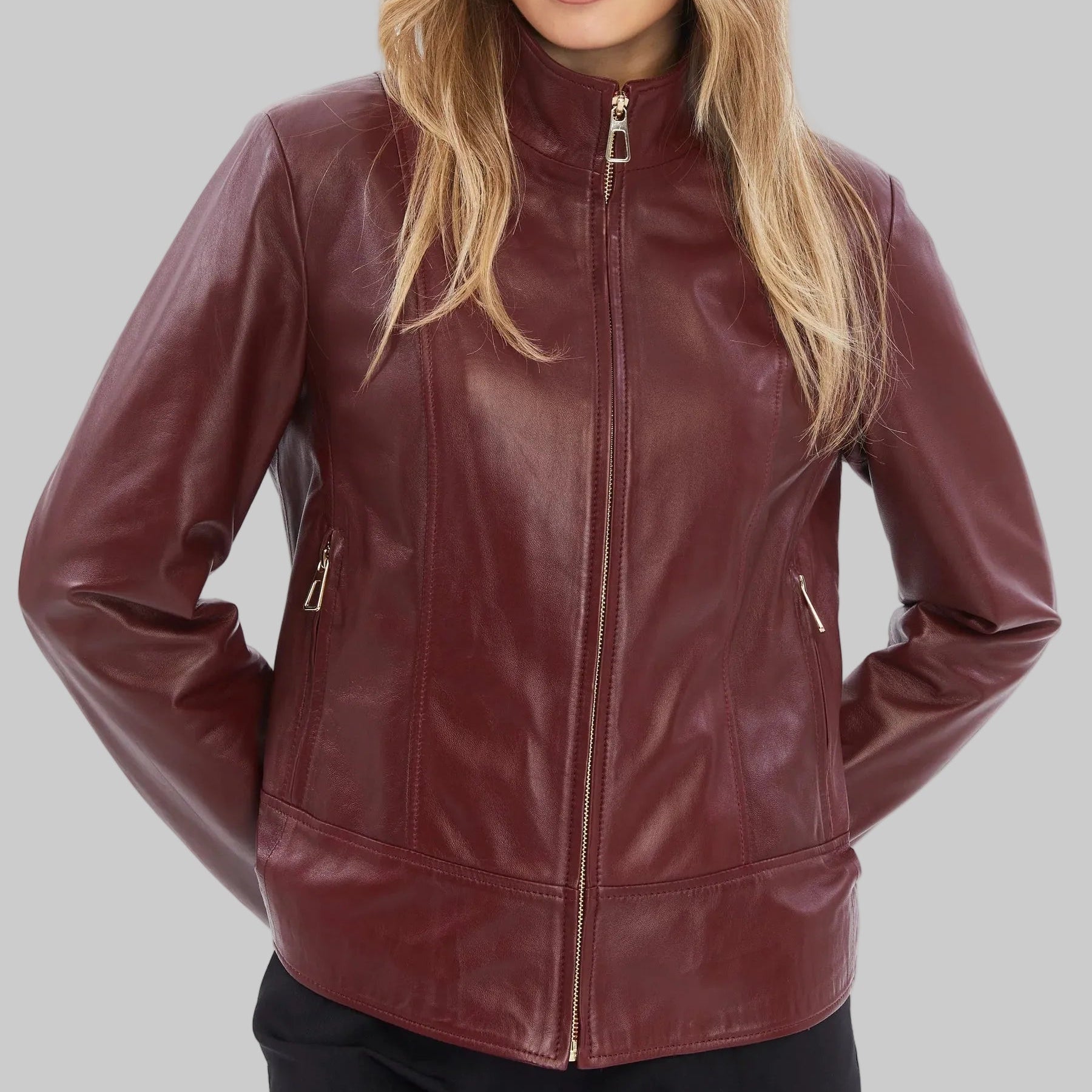 Woman wearing a maroon leather jacket on a white background