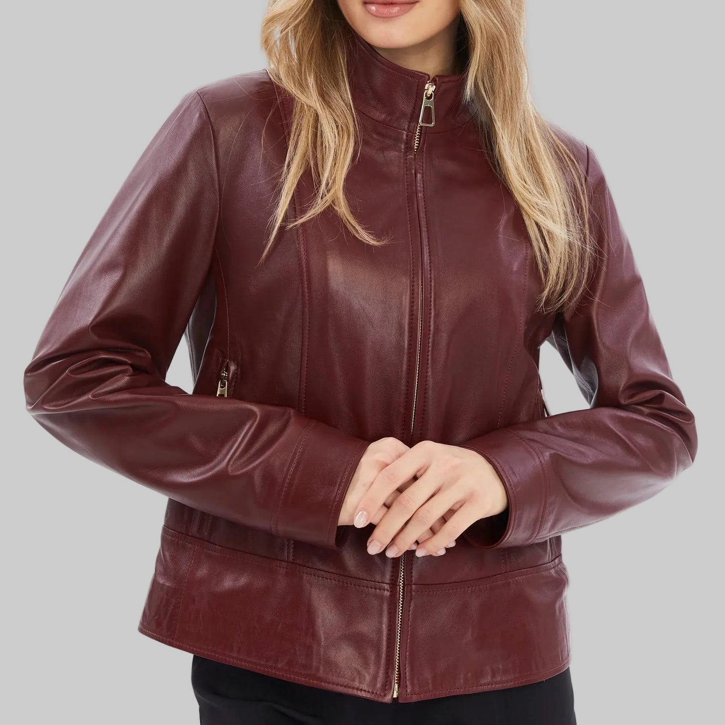 Woman wearing a burgundy leather jacket on a white background