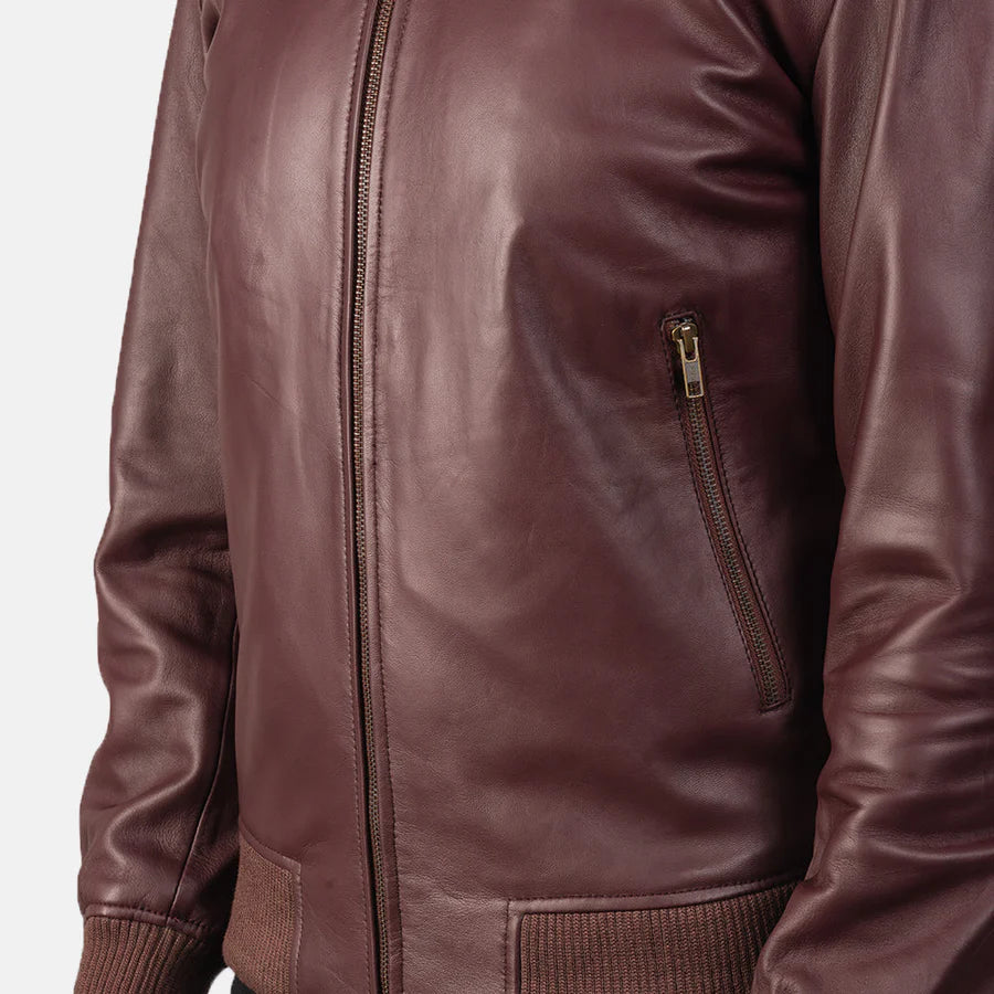 Burgundy leather bomber jacket worn by a person on a white background