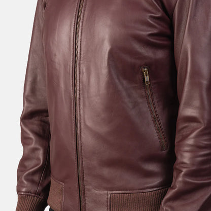 Burgundy leather bomber jacket worn by a person on a white background