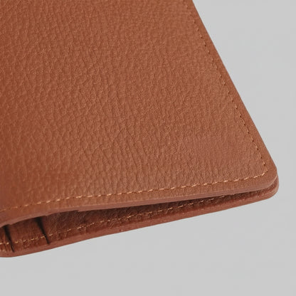 Close-up of a brown leather wallet on a light gray background
