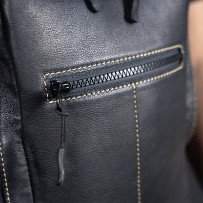 Close-up of a black leather backpack with a zipper