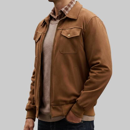 Man wearing a brown jacket over a plaid shirt on a white background