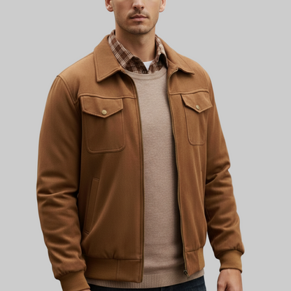 Man wearing a brown jacket over a plaid shirt on a white background