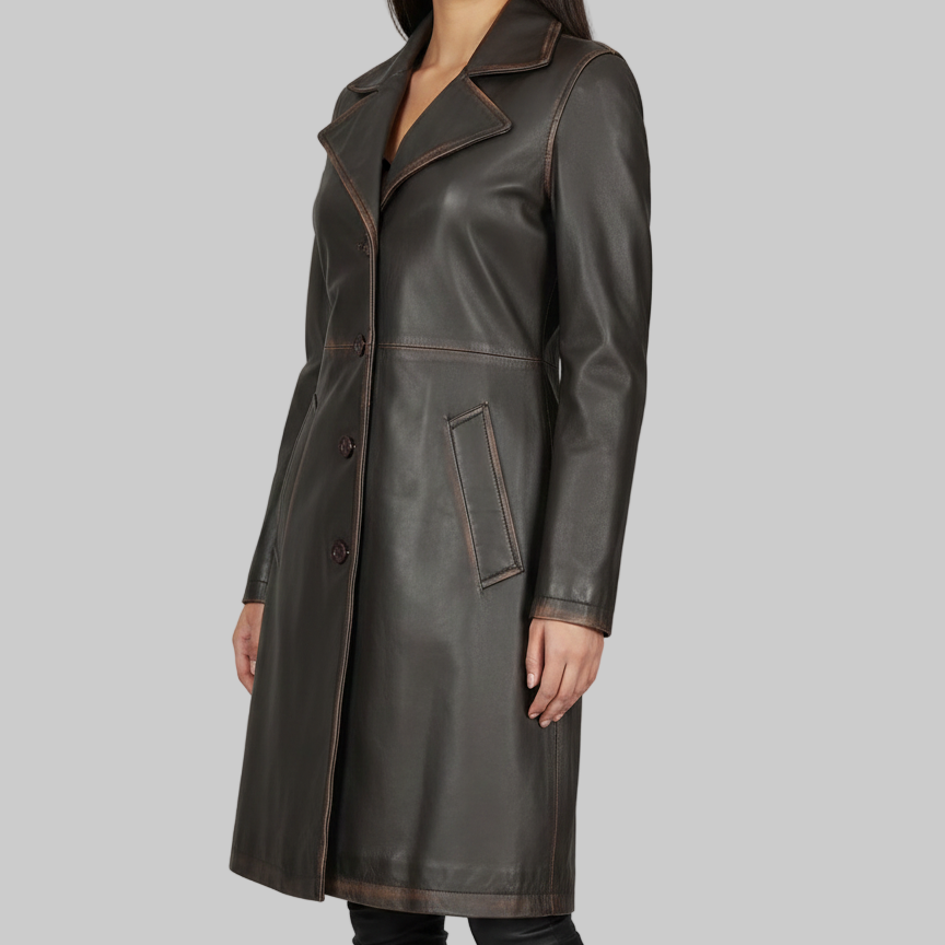 Woman wearing a long dark leather coat on a gray background