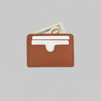 Brown leather cardholder with currency on a light gray background