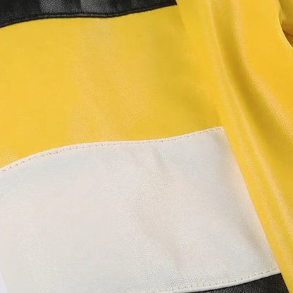 Close-up of a jacket with black, yellow, and white color block design on a white background