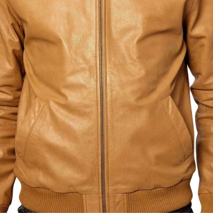 Close-up of a tan leather jacket with a zipper on a white background