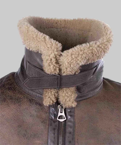 Close-up of a brown leather jacket with a fur-lined collar on a white background