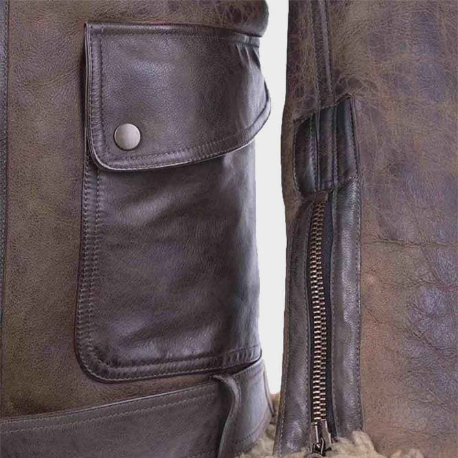 Close-up of a brown leather jacket with a pocket and zipper detail.