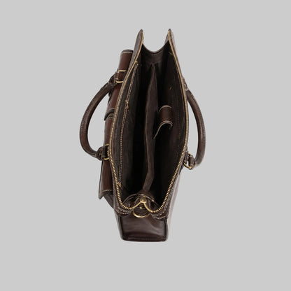A dark brown leather tote bag shown from a top-down view, featuring dual top handles, a zippered main compartment, and a zippered side pocket with gold-tone metal hardware, set against a plain white background.