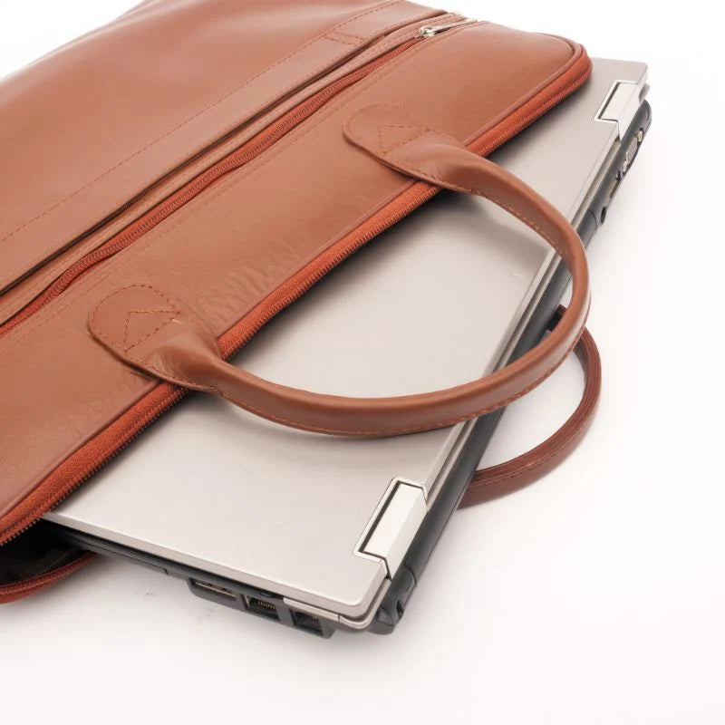 Brown leather laptop bag with a silver laptop inside on a white background