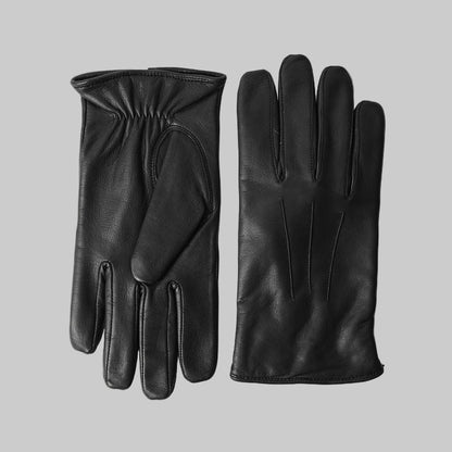 Pair of black leather gloves on a light gray background