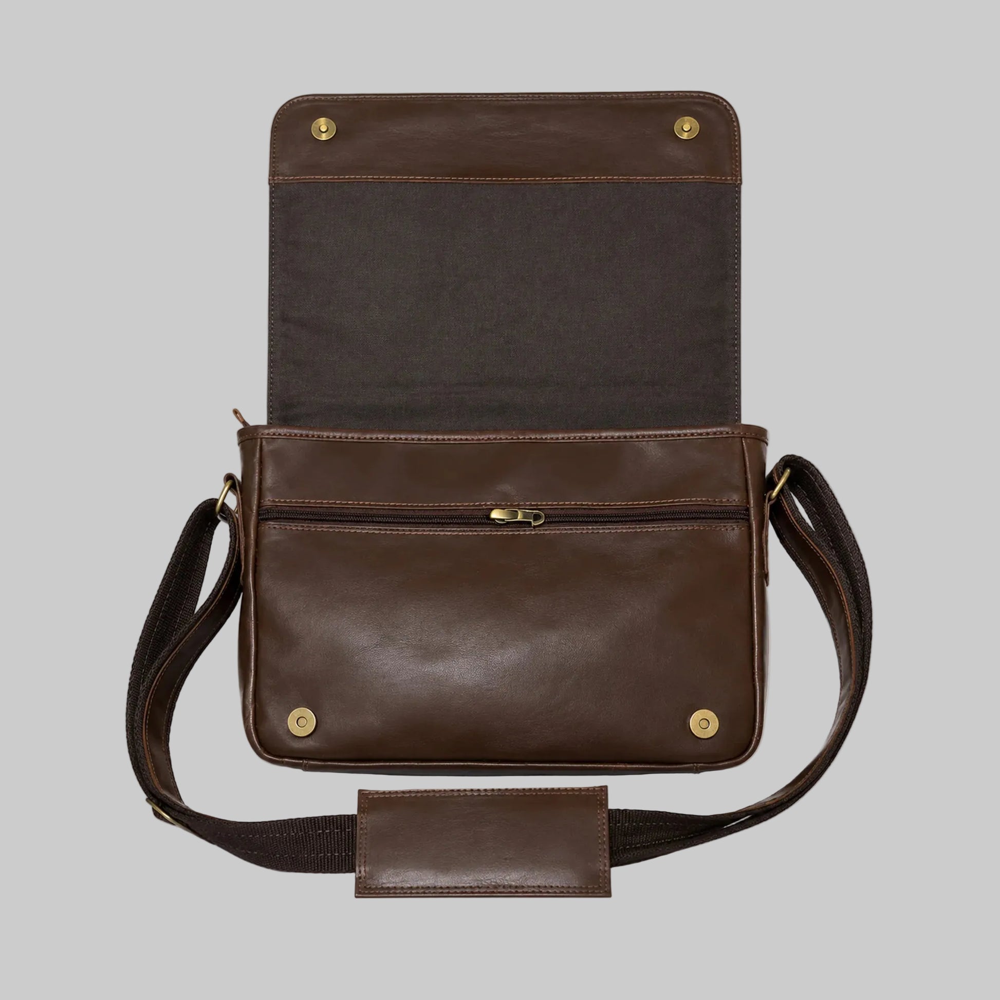 A dark brown leather messenger bag shown open against a white background, featuring a front zip pocket, adjustable shoulder strap, and brass hardware.