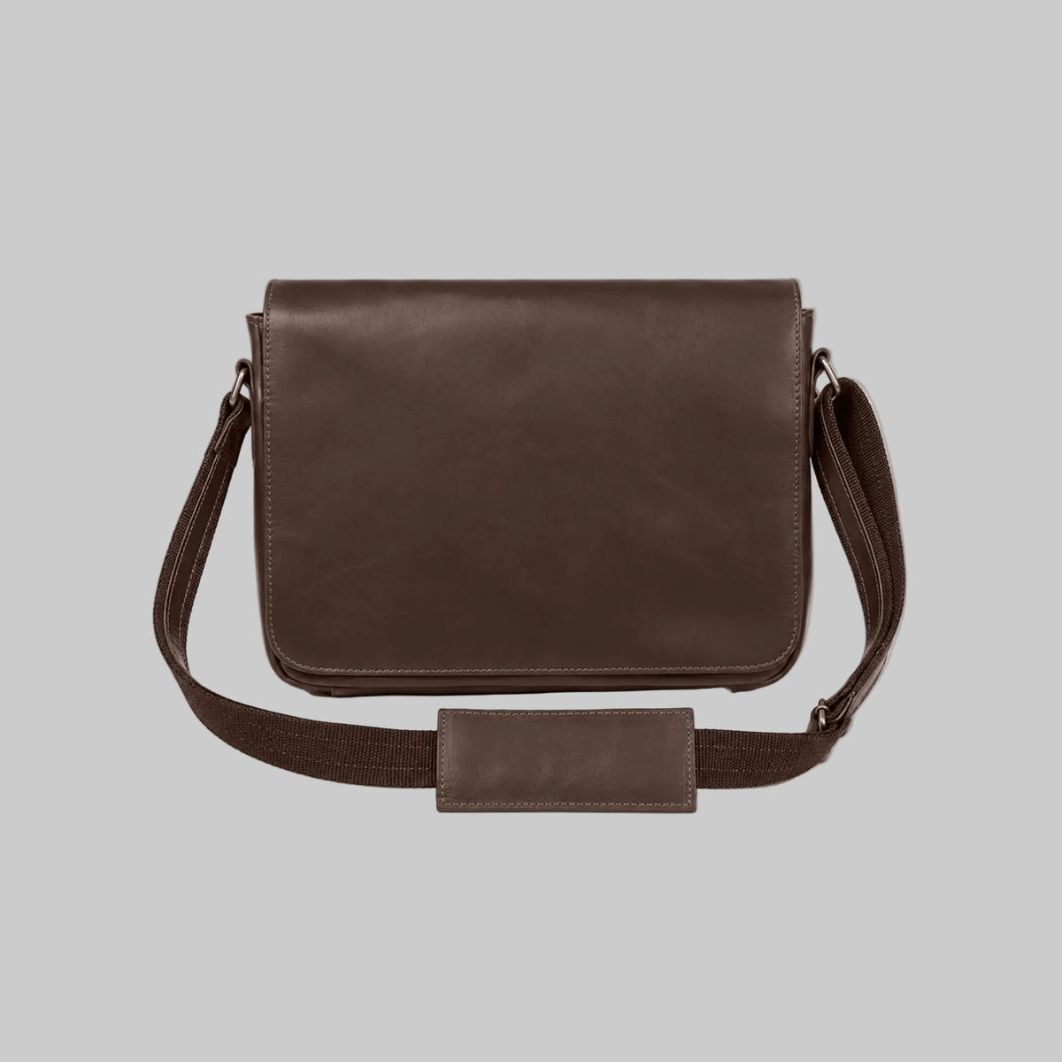 A dark brown leather messenger bag with a matching adjustable shoulder strap and a rectangular leather detail on the front, displayed against a solid white background.
