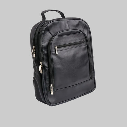 A black faux-leather backpack with multiple zippered compartments and silver-tone hardware, photographed on a seamless white background.