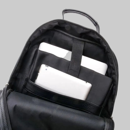 Black backpack with compartments holding white electronic devices on a white background