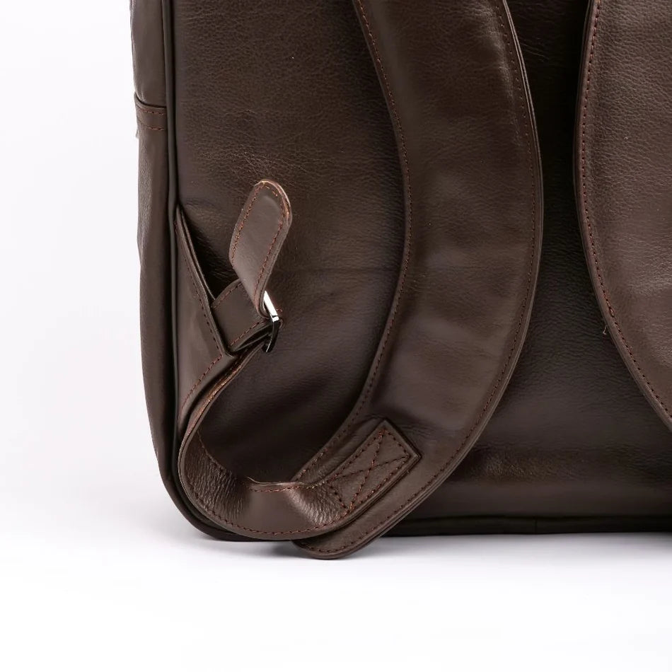 Close-up of a brown leather bag with a strap on a white background