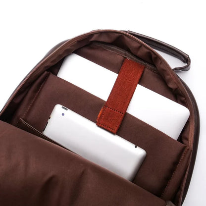 Brown backpack with a white tablet and red strap on a white background