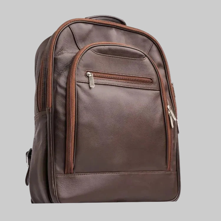 A dark brown faux-leather backpack with matching brown trim and silver zipper pulls, shown from a three-quarter angle on a white background.