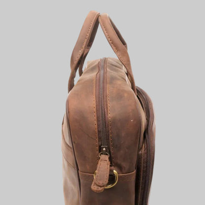 Brown leather bag with a gold zipper on a white background